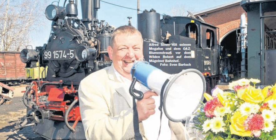 Alfred Simm mit seinem Megafon und dem OAZ-Blumenstrauß vor dem Wilden Robert auf dem Mügelner Bahnhof. Foto: Sven Bartsch